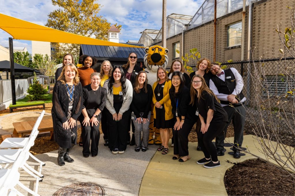 Early childhood professionals at MU's Child Development Lab pose with Mizzou's mascot Truman the Tiger on the play yard.