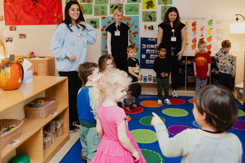 An early childhood classroom with preschool aged children and early childhood teachers and university students during a music lesson at the Child Development Lab.