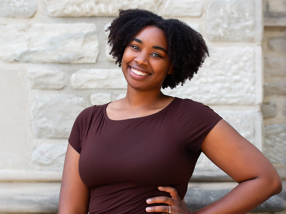 A woman with short brown hair wearing a brown shirt.