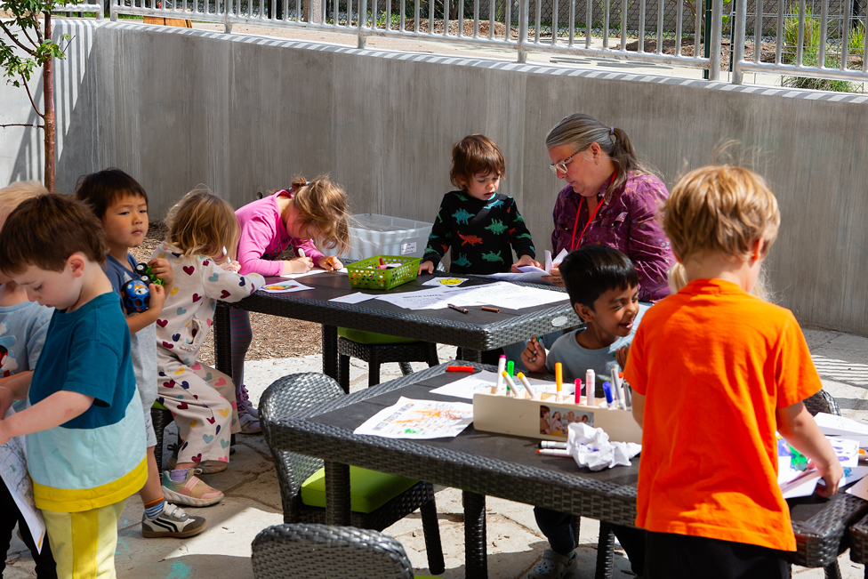 Children work on learning projects with an early childhood professional in the outdoor classroom at the Child Development Lab.